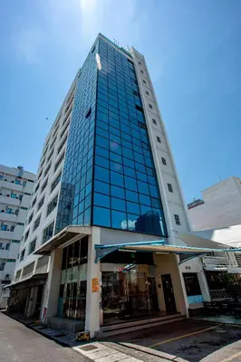 a tall building with glass windows on a street at PP Hotel Penang in George Town