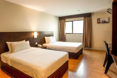 a hotel room with two beds and a window at PP Hotel Penang in George Town