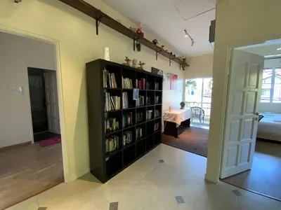 a living room with a book shelf filled with books at Highlanders Garden Guesthouse at Arundina Cameron Highlands in Cameron Highlands