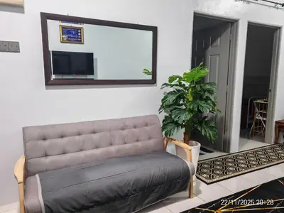 a couch in a living room with a mirror at Mieda Rizqi Homestay in Kampong Melayu Changkat Larah