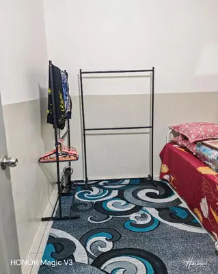 a room with a carpet on the floor next to a bed at Mieda Rizqi Homestay in Kampong Melayu Changkat Larah