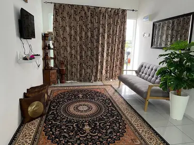 a living room with a couch and a rug at Mieda Rizqi Homestay in Kampong Melayu Changkat Larah