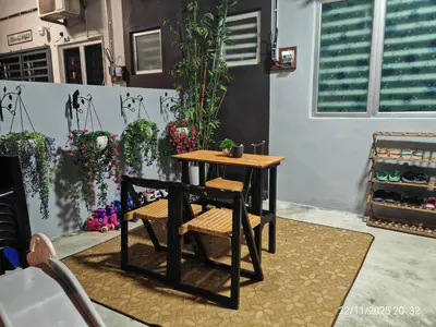 a table and a chair in a room with plants at Mieda Rizqi Homestay in Kampong Melayu Changkat Larah