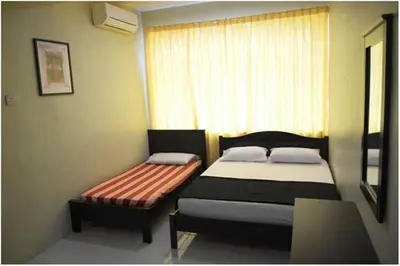 a small bedroom with two beds and a window at D'Mudah Motel & Homestay in Kulim