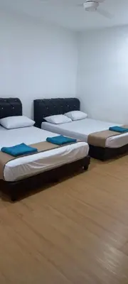 three beds are lined up in a room at D'Mudah Motel & Homestay in Kulim