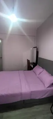 a bedroom with a purple bed with a light on it at Cosy Homestay Tanah Rata in Tanah Rata