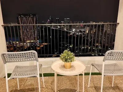 two chairs and a table on a balcony with a view at LM HomeyA 3 BdRm Coastline View condo for 4-14 Pax with Netflix & Coway Water Purifier in Tanjong Tokong
