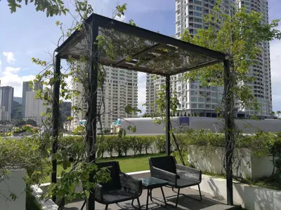 a gazebo with chairs and a table in a city at LM HomeyA 3 BdRm Coastline View condo for 4-14 Pax with Netflix & Coway Water Purifier in Tanjong Tokong