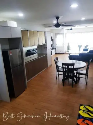a kitchen and living room with a table and chairs at Best Sekinchan homestay in Sekincan