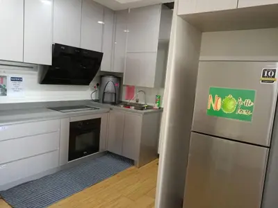a kitchen with white cabinets and a stainless steel refrigerator at Best Sekinchan homestay in Sekincan