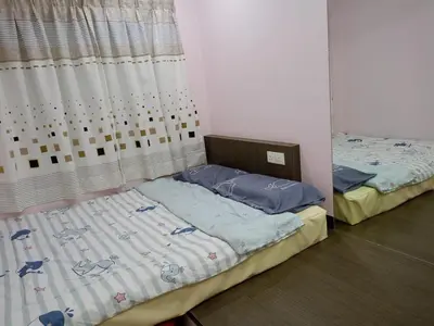 two twin beds in a room with a window at Best Sekinchan homestay in Sekincan