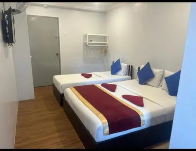 two beds in a hotel room with two beds sidx sidx sidx at ESM Hotel in Tanah Rata