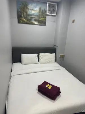 a bed in a room with a purple towel on it at ESM Hotel in Tanah Rata