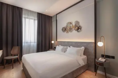 a bedroom with a large white bed and a window at FUHOTEL in Bukit Mertajam
