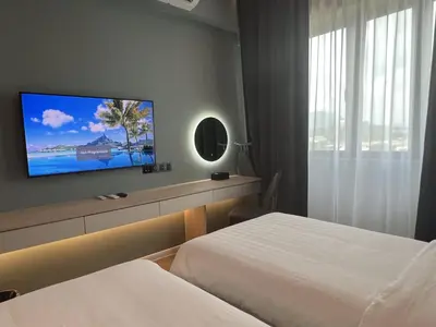 a hotel room with two beds and a flat screen tv at FUHOTEL in Bukit Mertajam