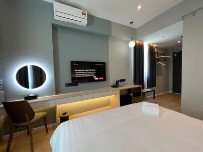 a hotel room with a bed and a flat screen tv at FUHOTEL in Bukit Mertajam