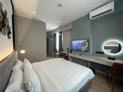a bedroom with a white bed and a tv at FUHOTEL in Bukit Mertajam