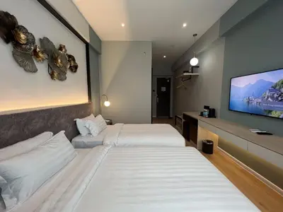 a hotel room with two beds and a flat screen tv at FUHOTEL in Bukit Mertajam