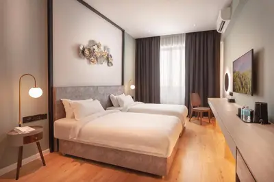 a hotel room with two beds and a desk at FUHOTEL in Bukit Mertajam