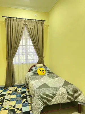 a bedroom with a bed with a smiley face pillow on it at Homestay Salak 756 at Sungai Siput Kuala Kangsar for Islamic Guest Only in Sungai Siput