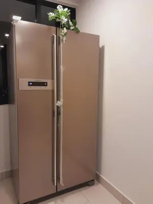a stainless steel refrigerator with flowers on top of it at The Landmark Comfort Relax Spacious Sea View By IZ in Tanjong Tokong