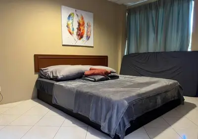 a bedroom with a bed with a blue comforter at CORAL BAY APARTMENT 3room (Ocean apartment) in Pangkor