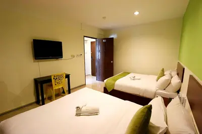 a hotel room with two beds and a television at Golden Roof Hotel Falim Ipoh in Ipoh