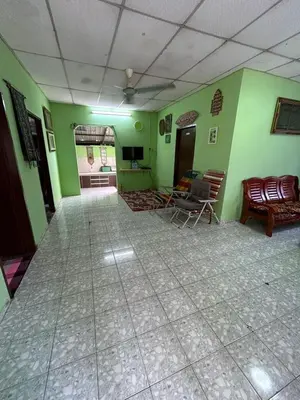 a room with green walls with chairs and a couch at Homestay Sham&Noi in Kuala Kangsar