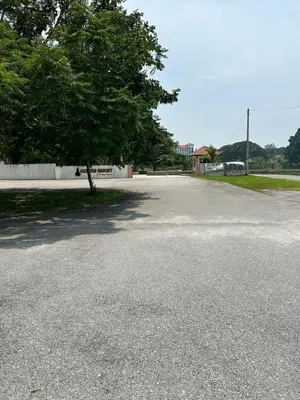 an empty street with a tree in the middle at Homestay Sham&Noi in Kuala Kangsar