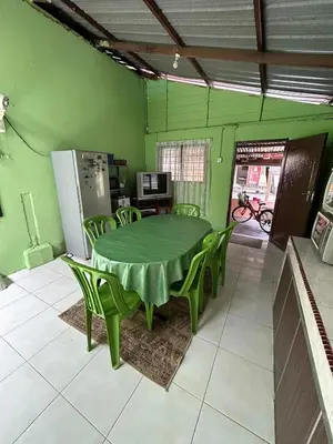 a green dining room with a table and green chairs at Homestay Sham&Noi in Kuala Kangsar