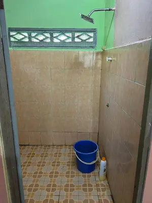 a bathroom with a bucket in the corner of a room at Homestay Sham&Noi in Kuala Kangsar
