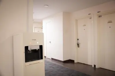 a room with white doors and a television on a wall at Golden Roof Hotel Ampang Ipoh in Ipoh