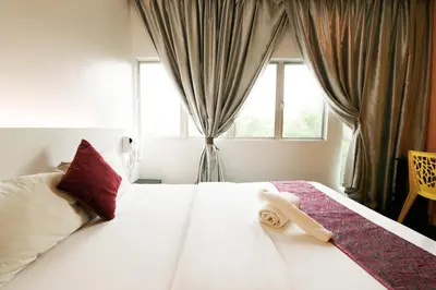 a hotel room with a bed with a towel on it at Golden Roof Hotel Ampang Ipoh in Ipoh