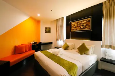 a hotel room with a bed and a chair at Golden Roof Hotel Ampang Ipoh in Ipoh