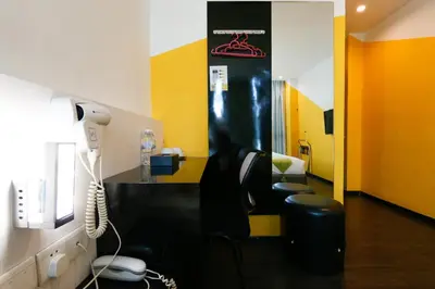 a room with a desk with two chairs and a phone at Golden Roof Hotel Ampang Ipoh in Ipoh