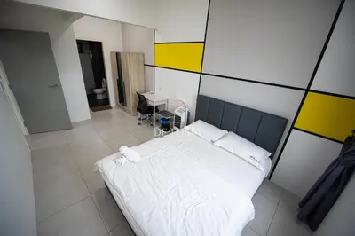 a bedroom with a white bed and a yellow and white wall at De Luma - Meritus in Perai