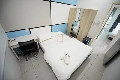 a hospital room with a bed and a desk and a chair at De Luma - Meritus in Perai