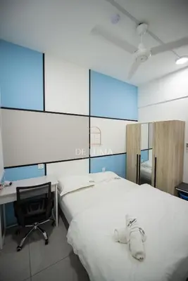 a bedroom with a bed and a desk and a chair at De Luma - Meritus in Perai