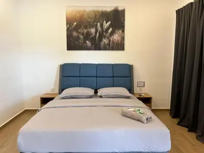 a bed with a blue headboard in a bedroom at Raintown Cottage in Taiping