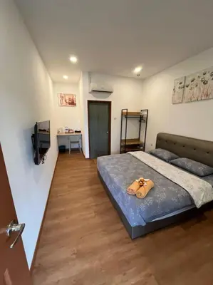 a bedroom with a bed with a pair of shoes on it at Raintown Cottage in Taiping