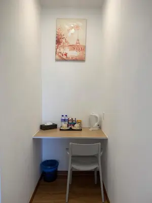 a desk in a room with a chair and a painting at Raintown Cottage in Taiping