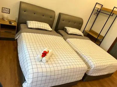 a bedroom with two twin beds with towels on them at Raintown Cottage in Taiping