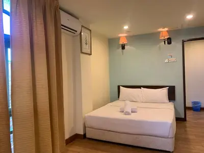 a bedroom with a white bed with two candles on it at D'Feringghi Hotel in Batu Ferringhi
