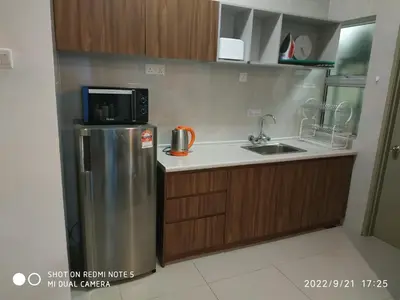 a kitchen with a stainless steel refrigerator and a microwave at The Gallery Camerons, cosy for the whole family in Brinchang