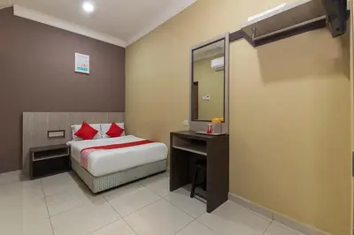 a bedroom with a bed and a desk and a mirror at Silibin Times Inn Hotel in Ipoh