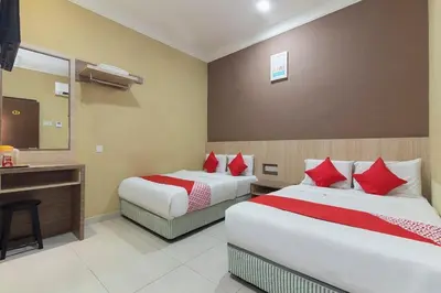 a hotel room with two beds and a desk at Silibin Times Inn Hotel in Ipoh