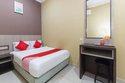 a bedroom with a bed with a mirror and a stool at Silibin Times Inn Hotel in Ipoh