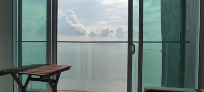 a bench sitting in front of a glass window at Infinite Seaview with Penang Bridge Suite with Sunrise up to 11 person in Bayan Lepas