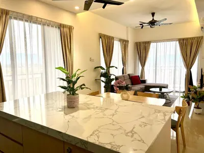 a kitchen and living room with a marble counter top at Ipoh Tambun Cove Luxe Premium Suites in Ipoh