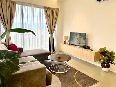 a living room with a couch and a tv at Ipoh Tambun Cove Luxe Premium Suites in Ipoh